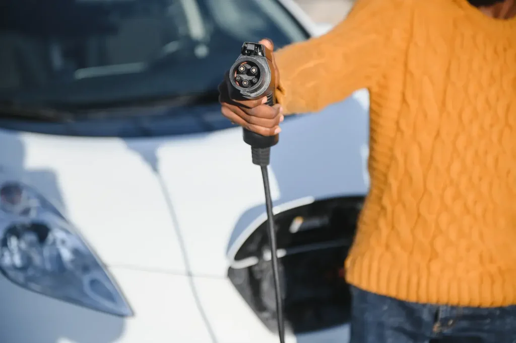 a woman holding a ev charging plug